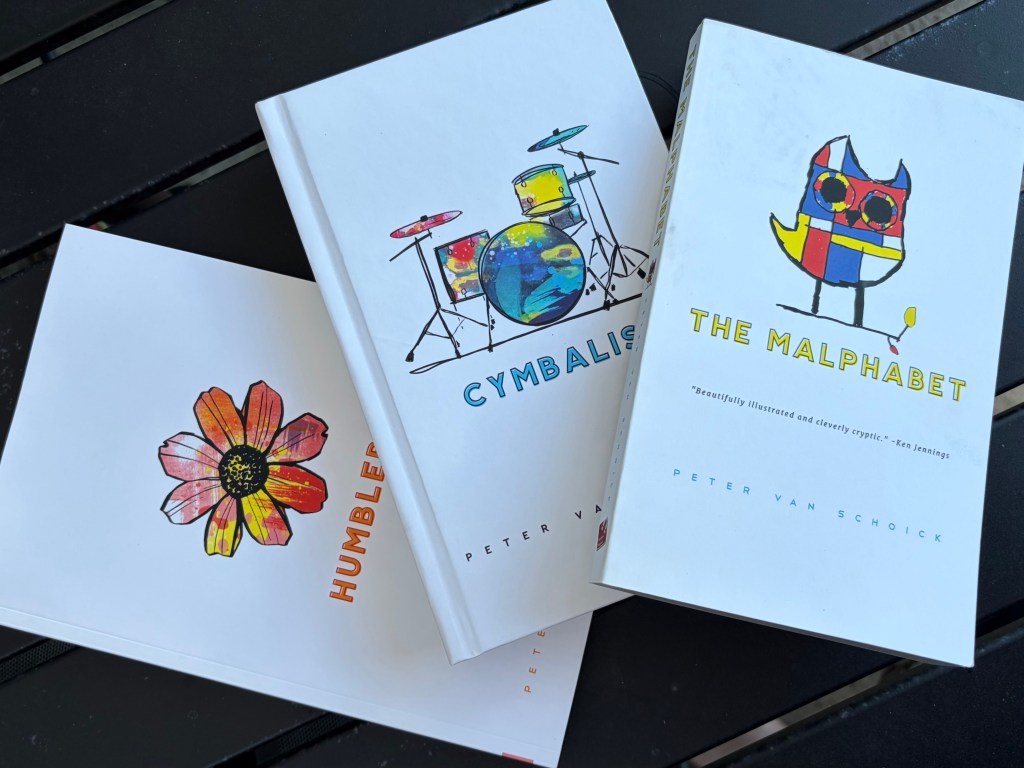 Photograph of hard cover and soft cover books The Malphabet, Humblebee and Cymbalism